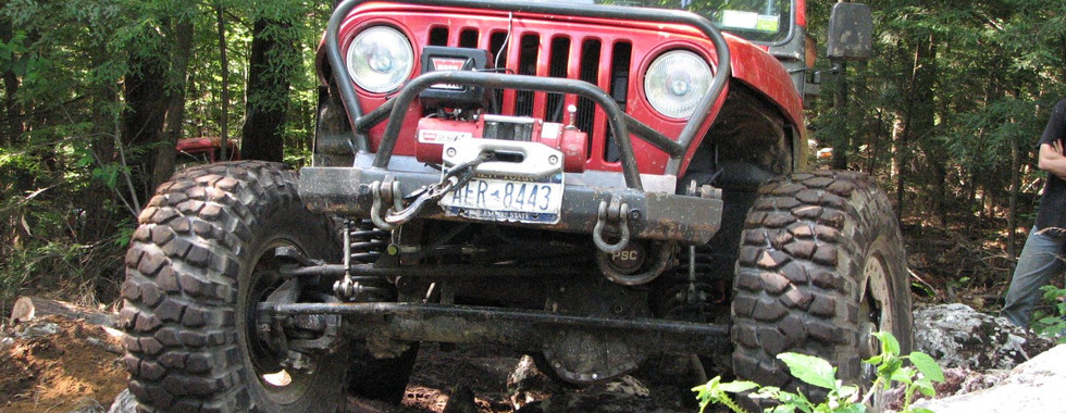 Red Jeep navigating rocky trail