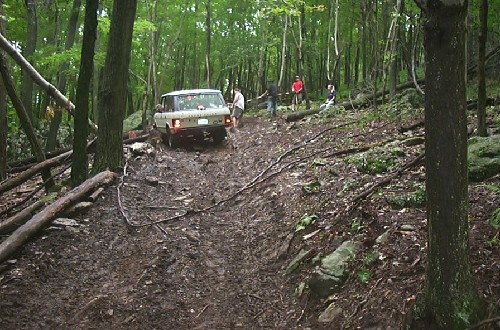 Land Rover stuck in mud, people assisting