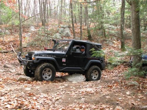 Black Jeep Wrangler navigating rocky trail