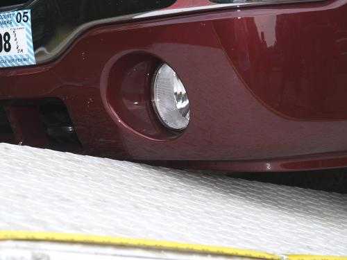 Red car front bumper on flatbed tow truck