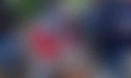 Man grilling hot dogs outdoors with group