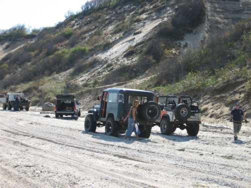 Jeeps and people on sandy trail