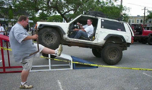 Man driving Jeep Cherokee over ramp, Long Island Off Road