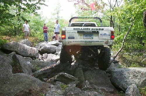 Toyota truck climbs rocks; people watch