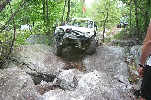 White Toyota truck navigating rocky terrain