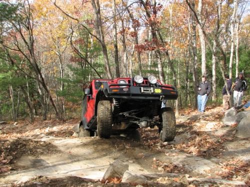 Red Jeep navigating rocky trail
