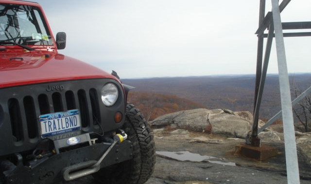 Red Jeep Wrangler at scenic overlook, TRAILBNJ plate
