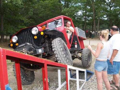 Man driving red Jeep up ramp