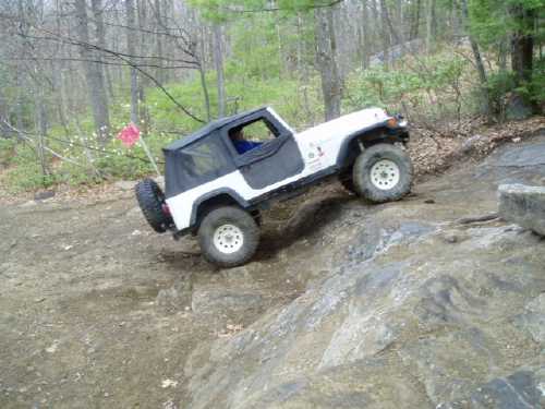 White Jeep navigating rocky trail