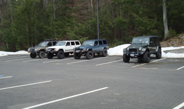 Four lifted SUVs parked