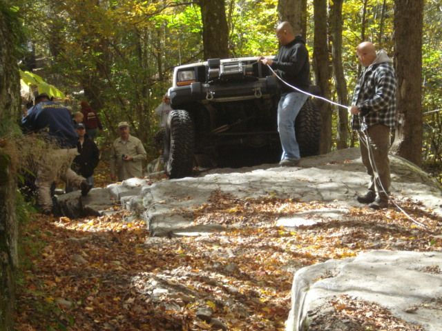 Off-roaders pulling Jeep on rocks