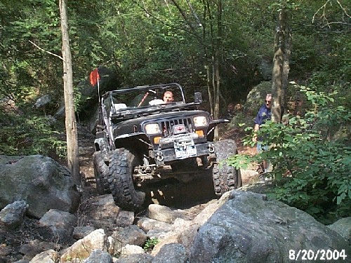 Man driving modified Jeep on rocky trail