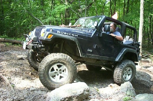 Man driving lifted Jeep Rubicon off-road