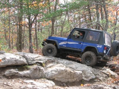 Blue Jeep navigating rocks on trail