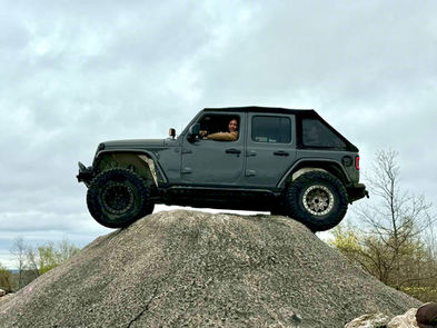 Jeep sitting on top of a large cement hill.
