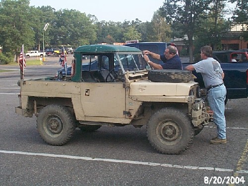 Two men working on a vintage Land Rover