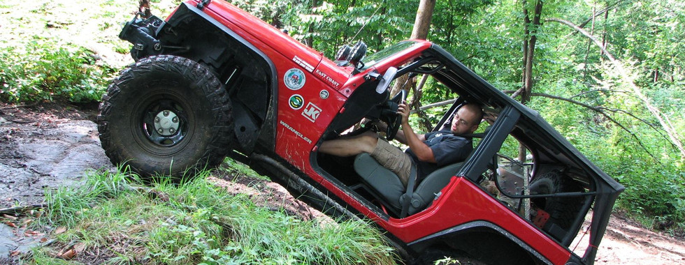 Red Jeep navigating rocky trail