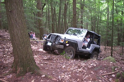 Jeep being pulled in woods
