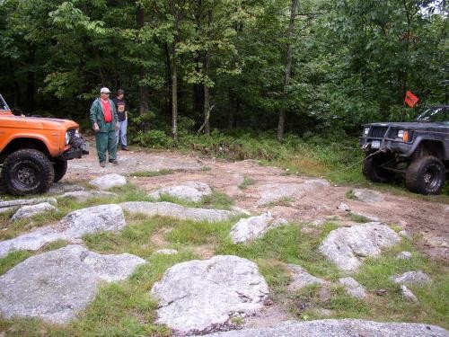 Two off-road vehicles parked near rocks