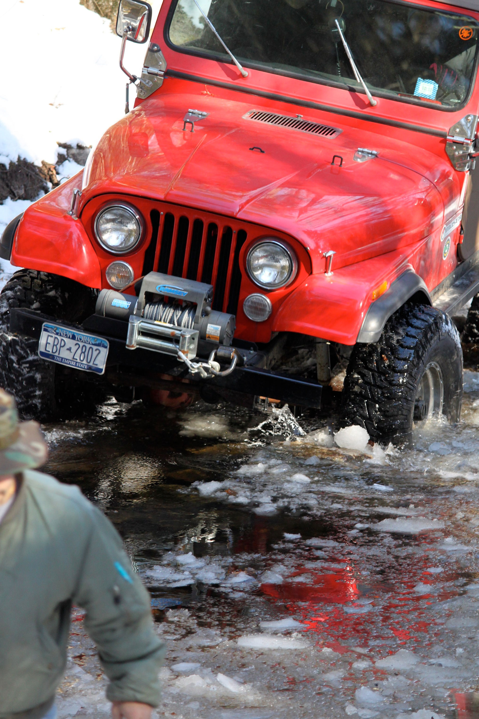 Red Jeep crossing stream