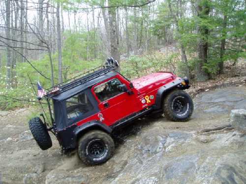 Red Jeep traversing rocky trail