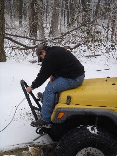 Man on snowy Jeep, winter off-roading