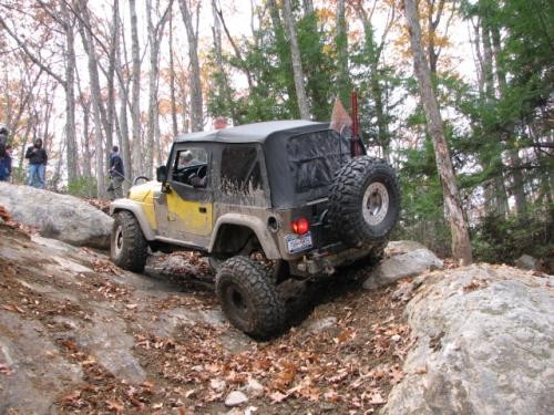 Yellow Jeep navigating rocky terrain