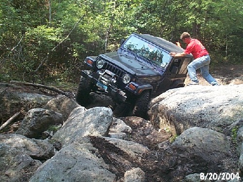 Man maneuvering Jeep over rocks