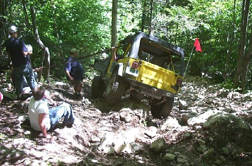Yellow Jeep navigating rocky trail