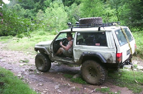 Man driving modified Jeep Cherokee off-road