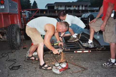Men using grinder to cut metal