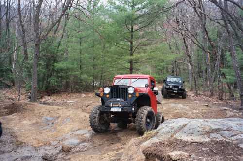 Red Jeep navigating rocky trail, Long Island Off Road
