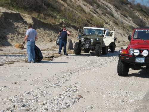 Volunteers cleaning beach, off-road vehicles