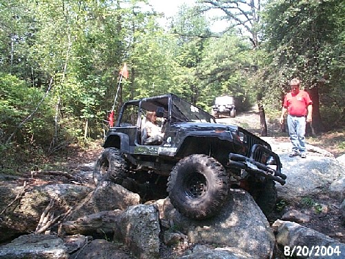 Black Jeep navigating rocks, off-road adventure