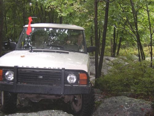 White Land Rover Range Rover navigating rocky terrain