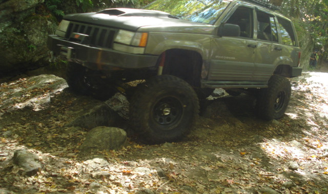 Lifted Jeep Cherokee tackling rocks on trail