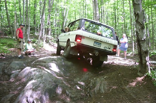 White Range Rover navigating rocky trail