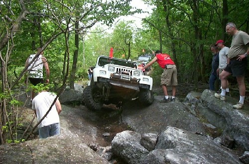 White Jeep navigating rocky terrain
