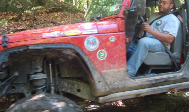 Man driving red Jeep on trail