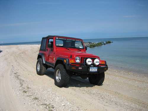 Red Jeep Wrangler on sandy beach