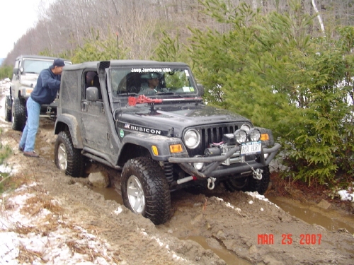 Jeep traversing muddy trail