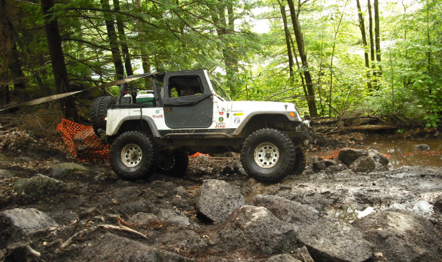White Jeep traversing rocky terrain