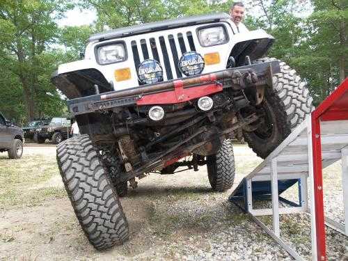 Man driving lifted Jeep up ramp