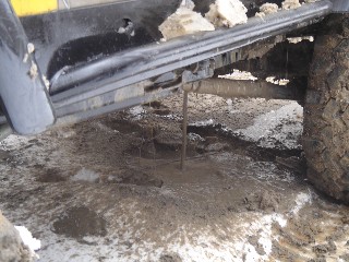 Jacked-up vehicle in muddy terrain