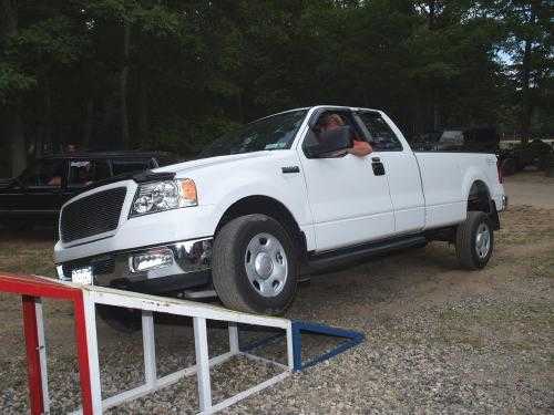 Man driving white Ford truck over ramp