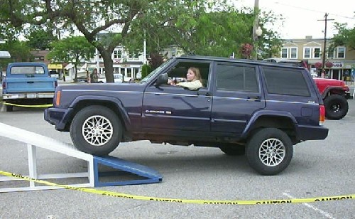 Woman driving Jeep Cherokee up ramp