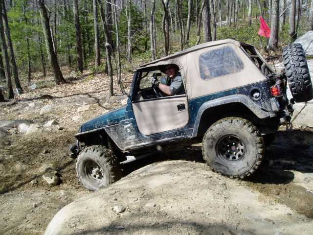Man driving Jeep on muddy trail