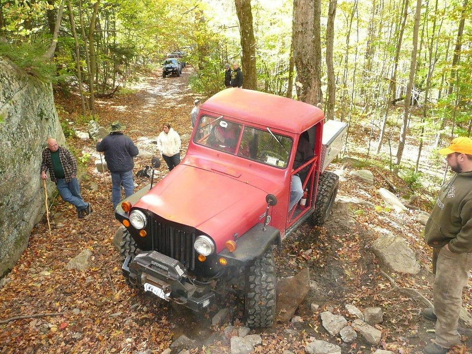 Red Jeep navigating rocky trail
