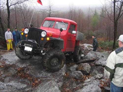 Red Jeep truck off-roading on rocks