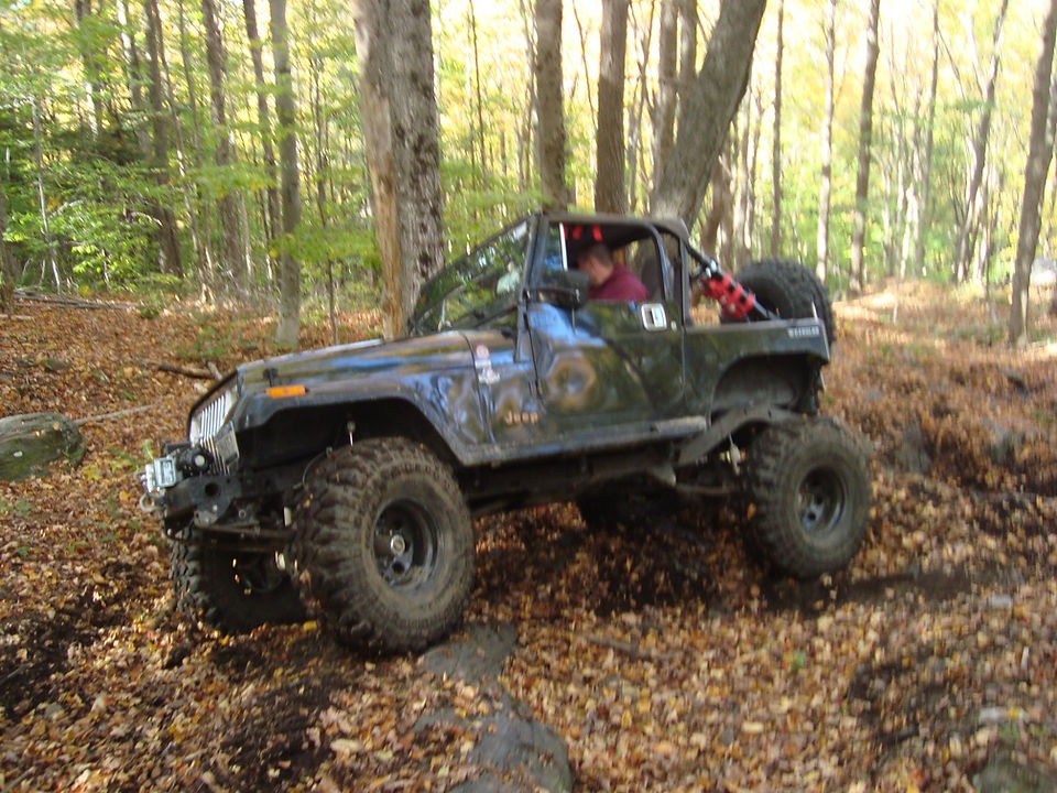 Man driving modified Jeep Wrangler on trail